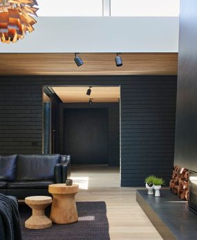 Central Park Road living room with black couch and timber side tables
